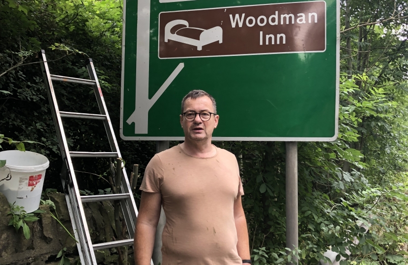 Cllr John Taylor cleaning road signs Kirkburton